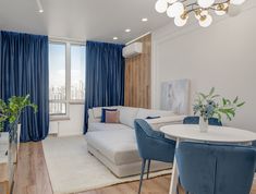 a living room filled with furniture and a white table in front of a large window