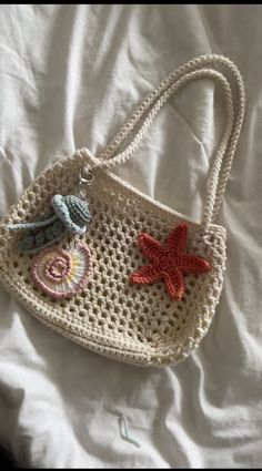 a crocheted handbag with starfish and seashells on the handle