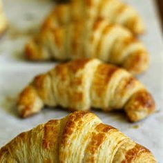 croissants are lined up on a baking sheet