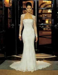 a woman in a white wedding dress standing on a floor next to an open door