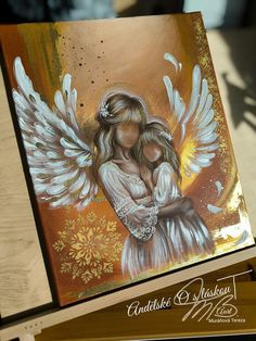 a painting of an angel holding a baby in her arms with gold and white wings