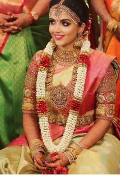 a woman sitting down wearing a bridal outfit