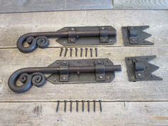 three different types of metal latches on a wooden floor with nails and screws