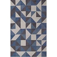 an area rug with blue and grey geometric shapes on the ground, in front of a white background