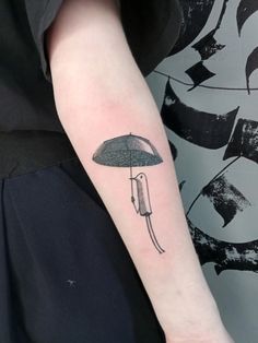 a person with a tattoo on their arm holding an umbrella