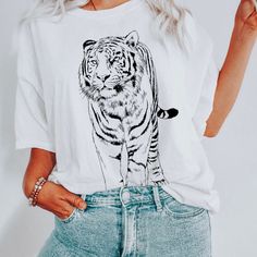 Hey tiger lovers! Show off your love for tigers with our vintage tiger face tshirt printed on a super soft comfort colors tshirt. MATERIAL ✨ Shirt sizes are Unisex, please refer to sizing chart in listing photos ✨ 100% ring-spun cotton ✨ Medium fabric weight ✨Relaxed fit ✨Sewn-in twill label CARE ✨ Machine wash: warm (max 40C or 105F) ✨ Do not iron directly on print ABOUT My love for design and clothing is what inspired the creation of this store.  During lockdown, I had so much free time and I Casual Cotton Tops With Tiger Print, Casual Cotton Tiger Print Tops, Casual White Tiger Print Top, Graphic Tee With Tiger Print And Short Sleeves, Tiger Print Graphic Tee With Short Sleeves, Short Sleeve Graphic Tee With Tiger Print, Cotton Graphic Tee With Tiger Print, Tiger Tshirt, Casual Summer T-shirt With Tiger Print