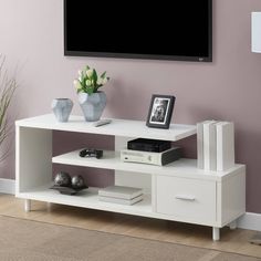 a white entertainment center in front of a flat screen tv