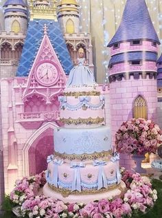 the cake is decorated with pink and blue icing, and has a princess castle on top