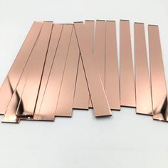 several pieces of copper foil on a white surface