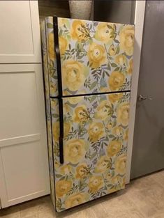 a refrigerator with yellow flowers painted on the front and bottom, sitting in a kitchen