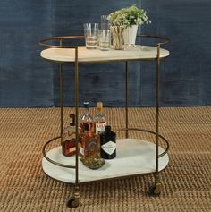 a bar cart with liquor bottles and glasses on it