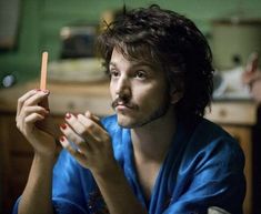 a man sitting at a table with a carrot in his hand