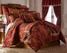 a bed covered in red and gold comforters