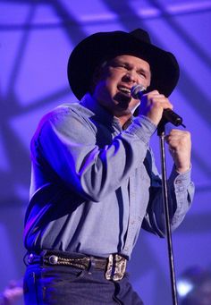 a man in a cowboy hat singing into a microphone