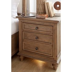 a night stand with two drawers and a lamp on top