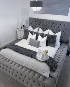 a bed that is made up with pillows and blankets on top of it in a room