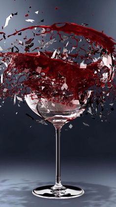 a wine glass with red liquid splashing out of it