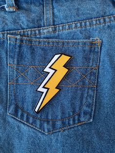 the back pocket of a pair of jeans with a lightning sticker on it