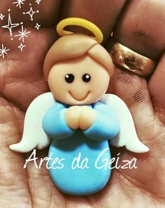 a small angel figurine sitting on top of someone's hand