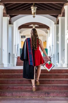 a woman in a red dress is walking down the stairs with her back to the camera