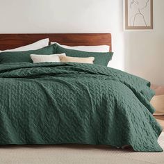 a bed with green bedspread and pillows