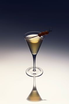 a martini glass with an olive garnish in it