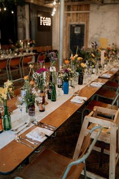 a long table is set up with flowers and wine bottles for an elegant wedding reception