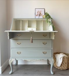 the dresser is painted in pale blue and has gold handles