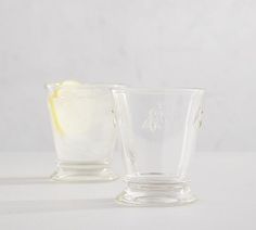 two clear glass cups with lemon wedges in them