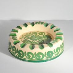 a green and white bowl sitting on top of a table