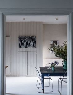 an open door leading to a dining room with a table and chairs in front of it