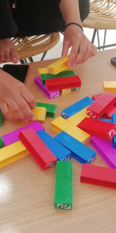 someone is playing with colored blocks on the table