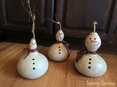 three snowmen sitting on top of each other in front of a wooden cabinet door