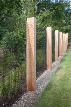 a row of wooden posts next to a fence