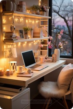 a laptop computer sitting on top of a desk next to a window with fairy lights