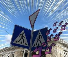 two street signs are shown in front of a building with blue sky and white clouds