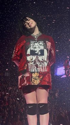 a woman standing on top of a stage wearing knee high socks and an oversized t - shirt