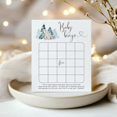 a white plate with a calendar on it next to a tree and snow covered ground