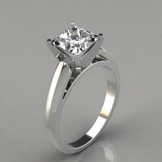 a white gold engagement ring with a single diamond in the center, on a gray background