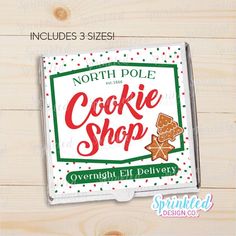 the north pole cookie shop sign is displayed on a wooden surface with white and green polka dots