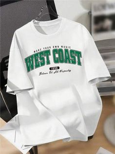 a white west coast t - shirt hanging on a clothes rack with other items in the background