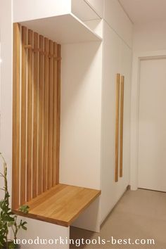 an empty room with wooden slats on the wall and a plant next to it