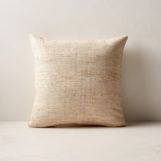 a beige pillow sitting on top of a white table