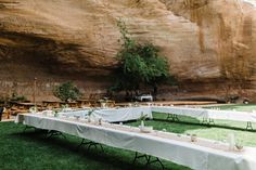 long tables set up in front of a cliff