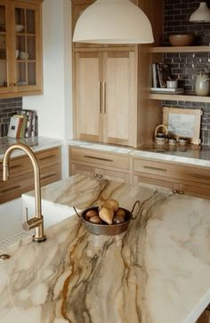 a kitchen with marble counter tops and wooden cabinets