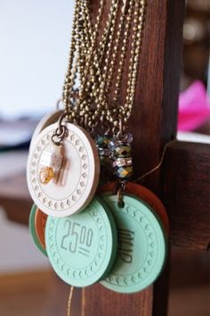 several necklaces are hanging from a wooden rack with beads and other jewelry on it