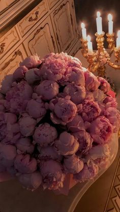 a bouquet of flowers sitting on top of a table next to a chandelier