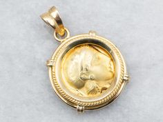 an antique gold locke with a woman's face in the center and roped edges