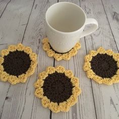 four crocheted coasters and a coffee cup on a wooden table