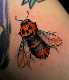 a close up of a tattoo with a bee on it